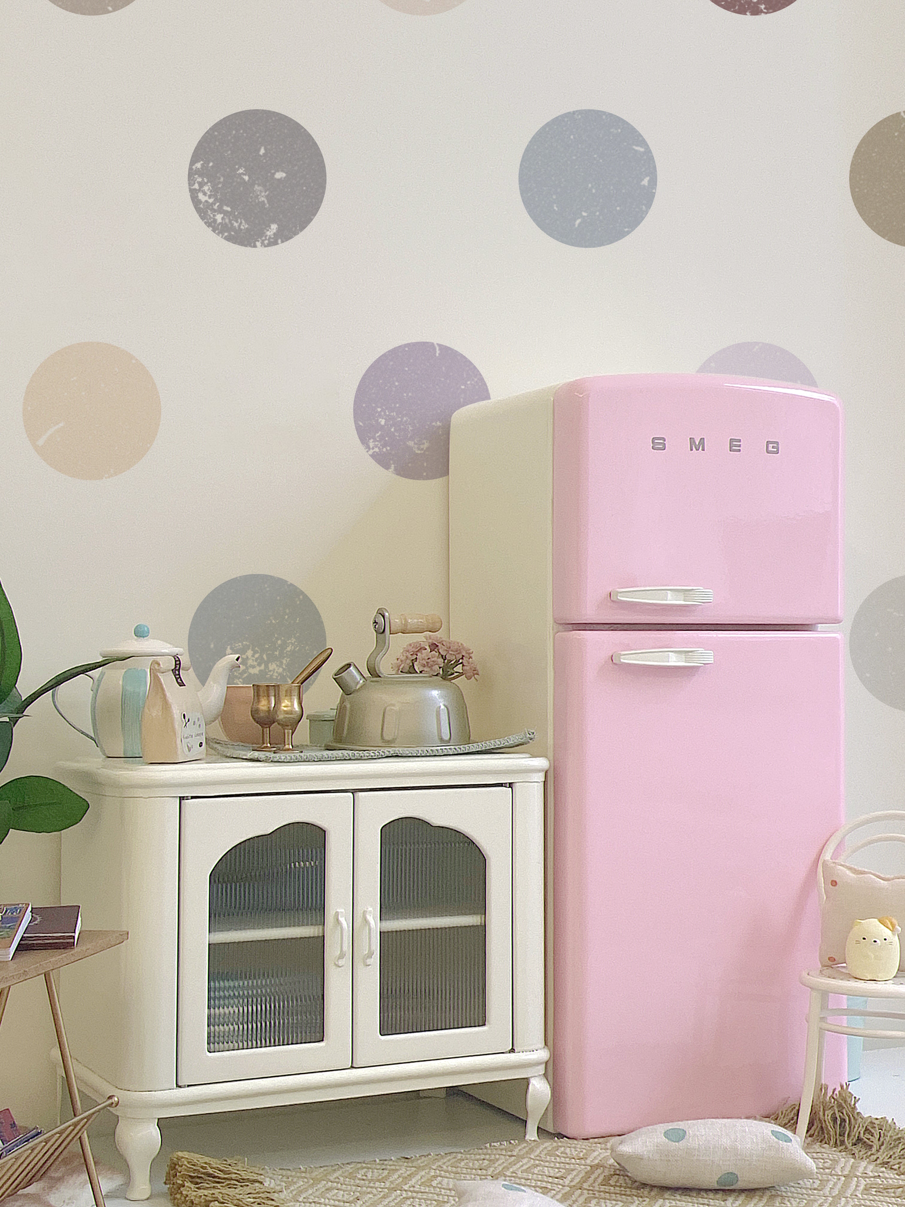 Closed pink dollhouse refrigerator in a kitchen scene with cabinet, kettle, plant and props not included