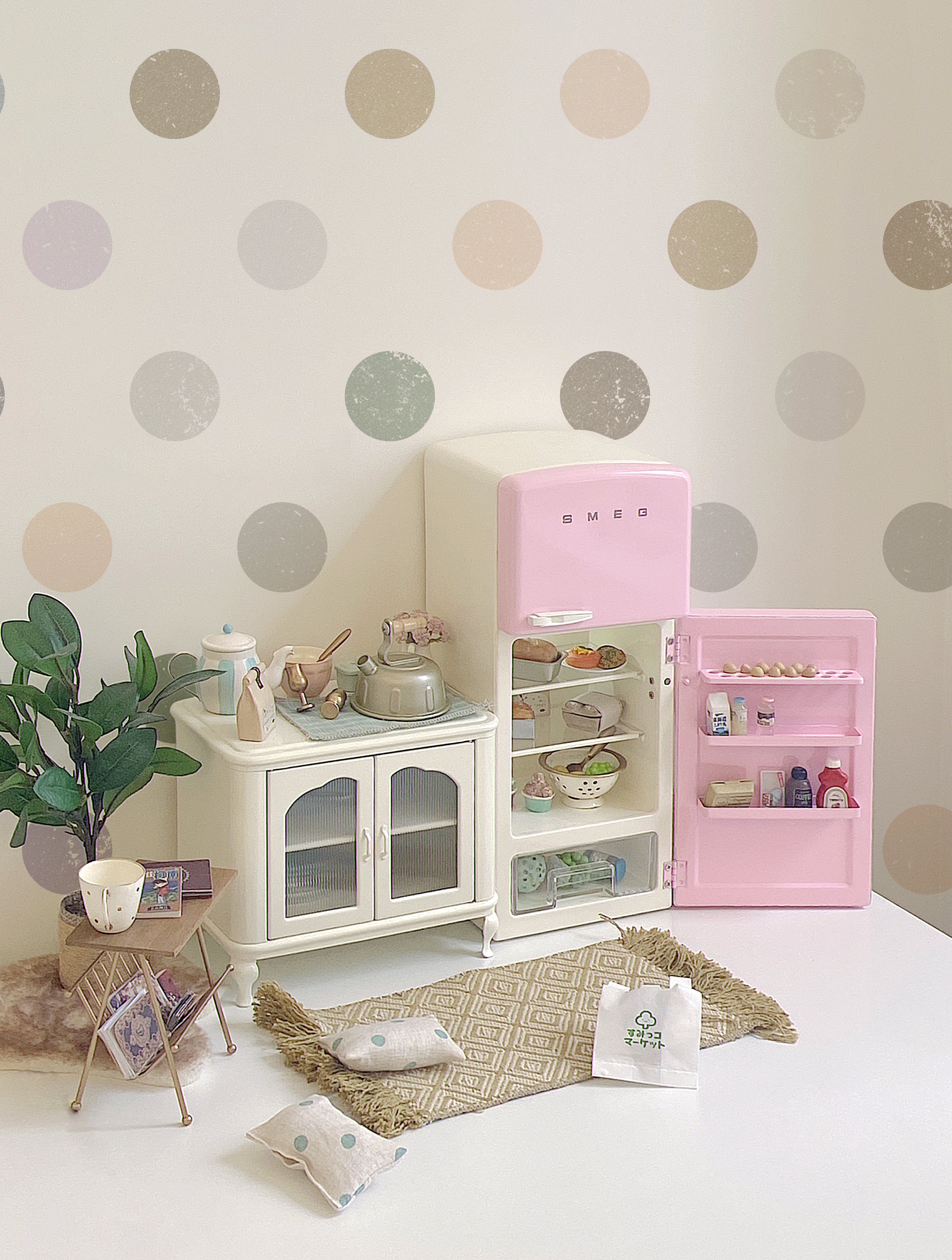 Open pink dollhouse refrigerator in a full kitchen scene with cabinet, plant, food and room props not included